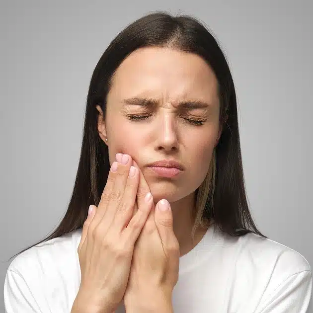 Stressed man suffering tooth ache standing alone in the street and going for help at Asha Dental Leawood KS